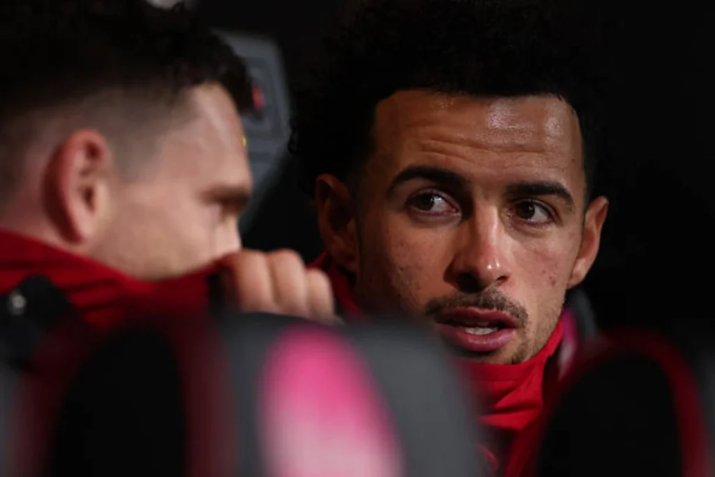 Curtis Jones sitting on the bench alongside Andy Robertson