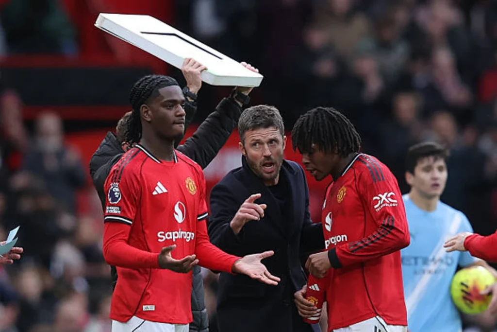Michael Carrick, caretaker head coach of Manchester United, issues instructions to Patrick Dorgu.